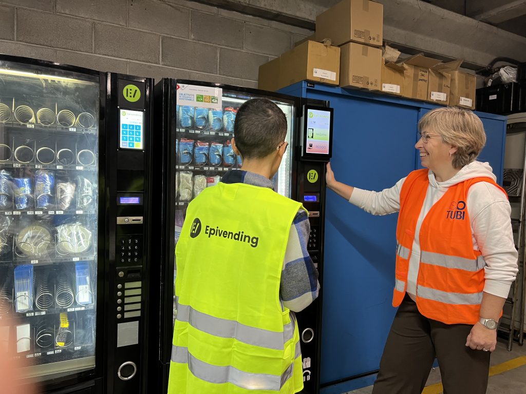 foto de un operario de epivending y un cliente frente a la máquina expendedora de equipos de protección individual y suministros.