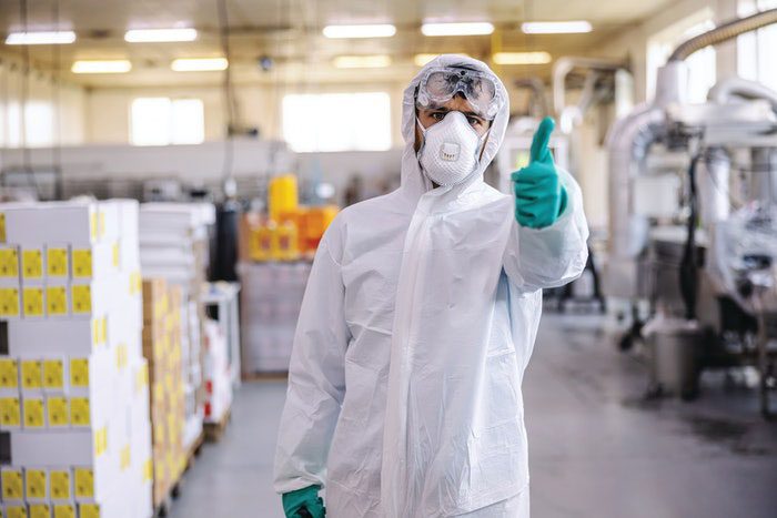 Máquina expendedora de EPIs con inteligencia artificial en una planta industrial alimentaria, trabajador identificándose con para coger epis.